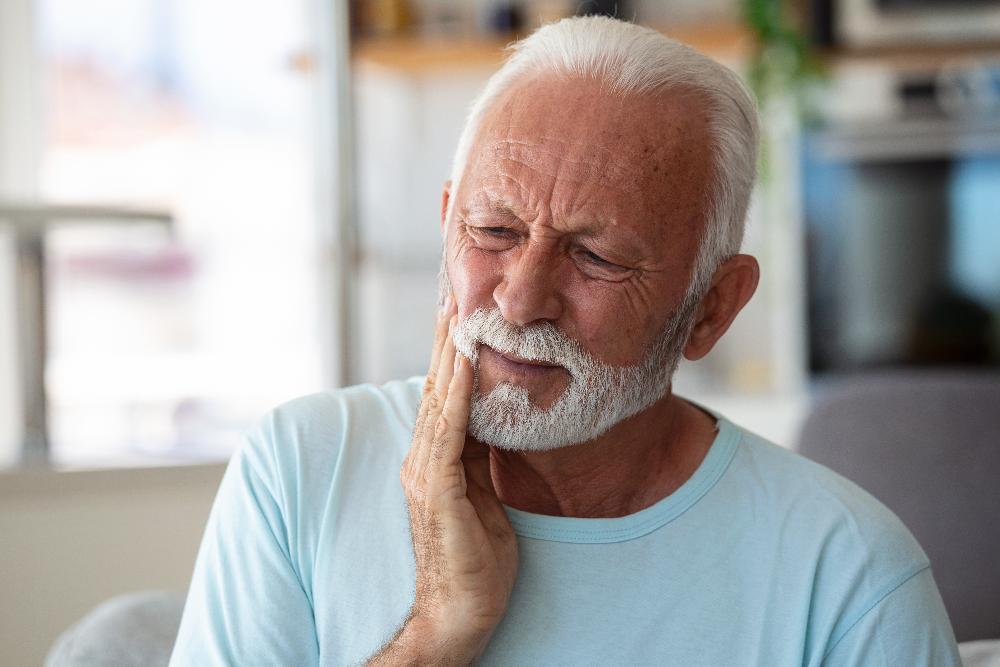 older man in pain holding jaw | cosmetic dentistry cookeville tn