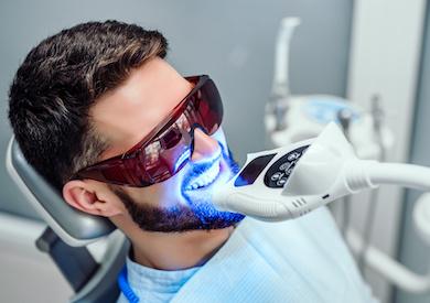 man receiving teeth whitening treatment | cosmetic dentist cookeville tn