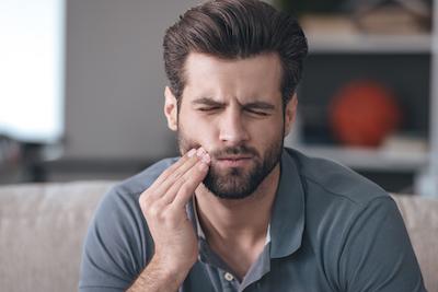 man in pain holding jaw | root canals cookeville tn