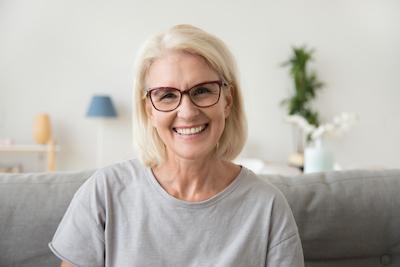 woman with glasses smiling | dental implants cookeville tn