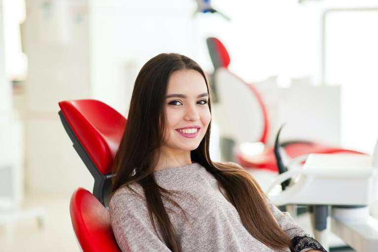 woman sitting in dentist chair | veneers cookeville tn