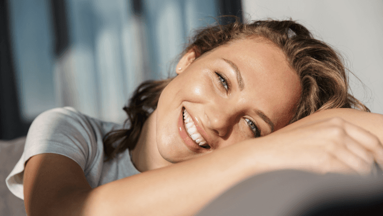 woman laying on couch | dental crowns cookeville tn